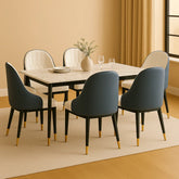 Dining room setup with a marble table and modern chairs in a well-lit room.