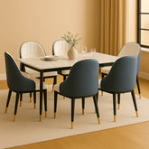Dining room setup with a marble table and modern chairs in a well-lit room.