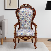 Decorative armchair with floral pattern and wooden frame in a room setting.