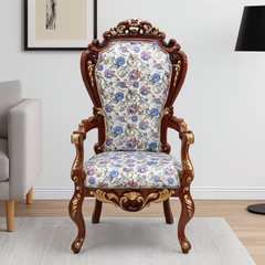 Decorative armchair with floral pattern and wooden frame in a room setting.