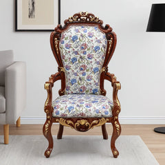 Decorative armchair with floral pattern and wooden frame in a room setting.