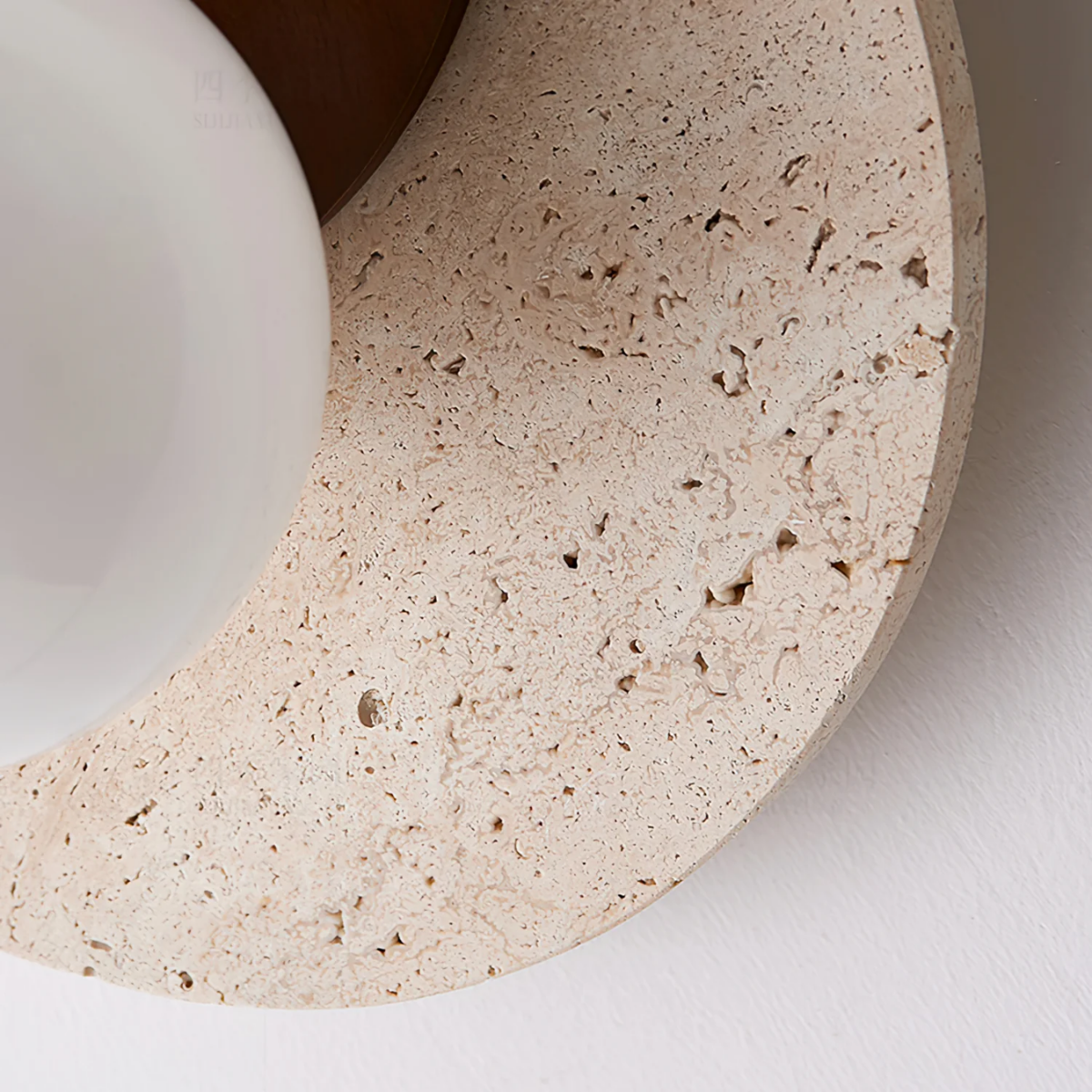 Close-up texture detail of the travertine stone disc and frosted glass globe on Lunara Wall Light