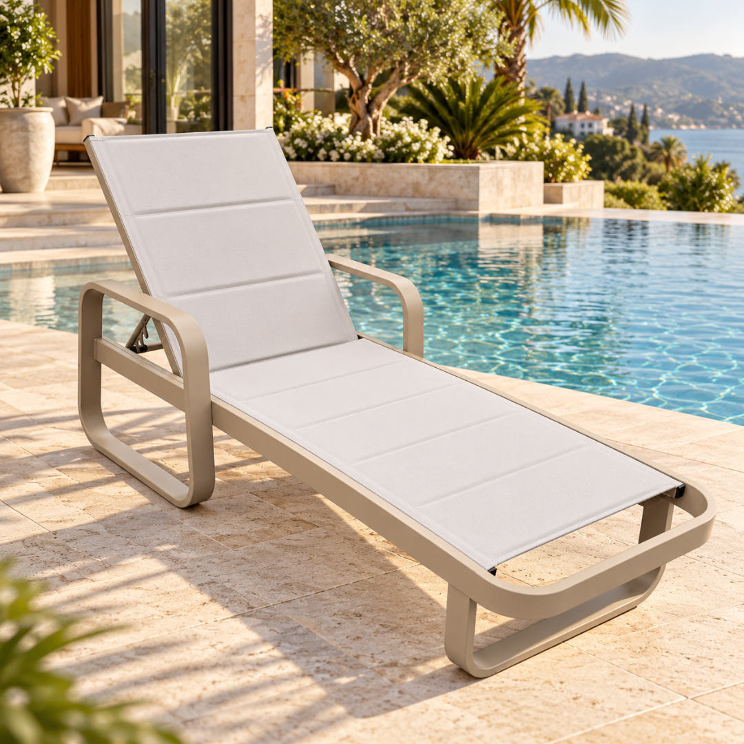Wooden Twist Positano aluminium sun lounger with padded light grey sling seat and curved arms beside a sea-view pool