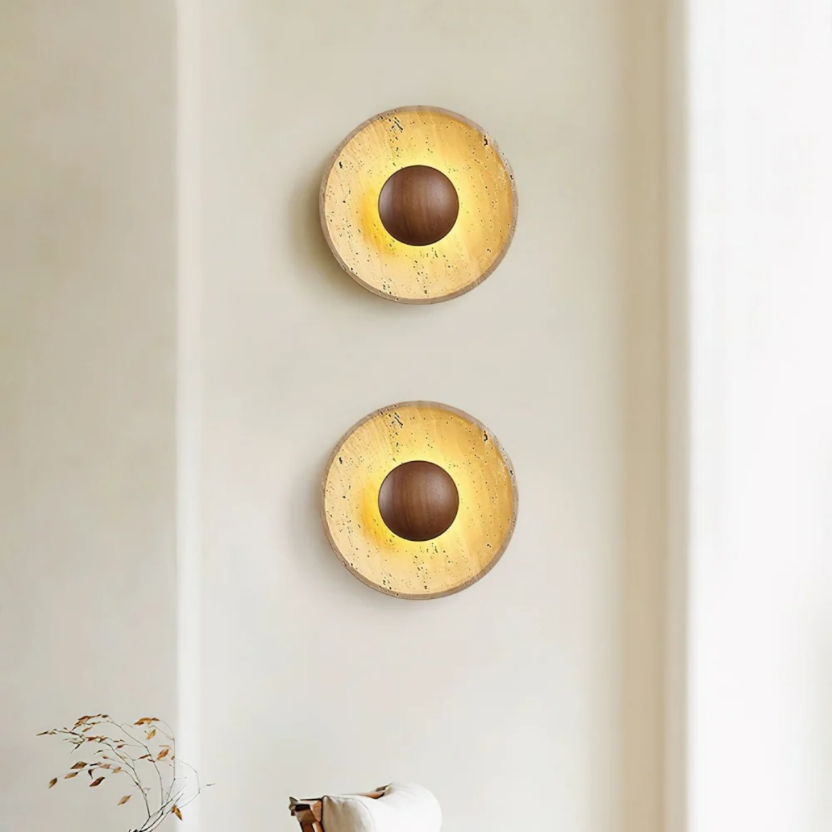 Two Solara Travertine Round Wall Lights mounted vertically in a hallway with warm ambient lighting