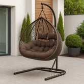 Brown hanging egg chair with cushions on a patio