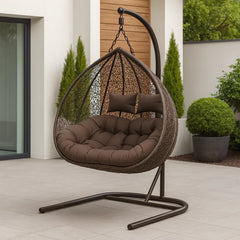 Brown hanging egg chair with cushions on a patio