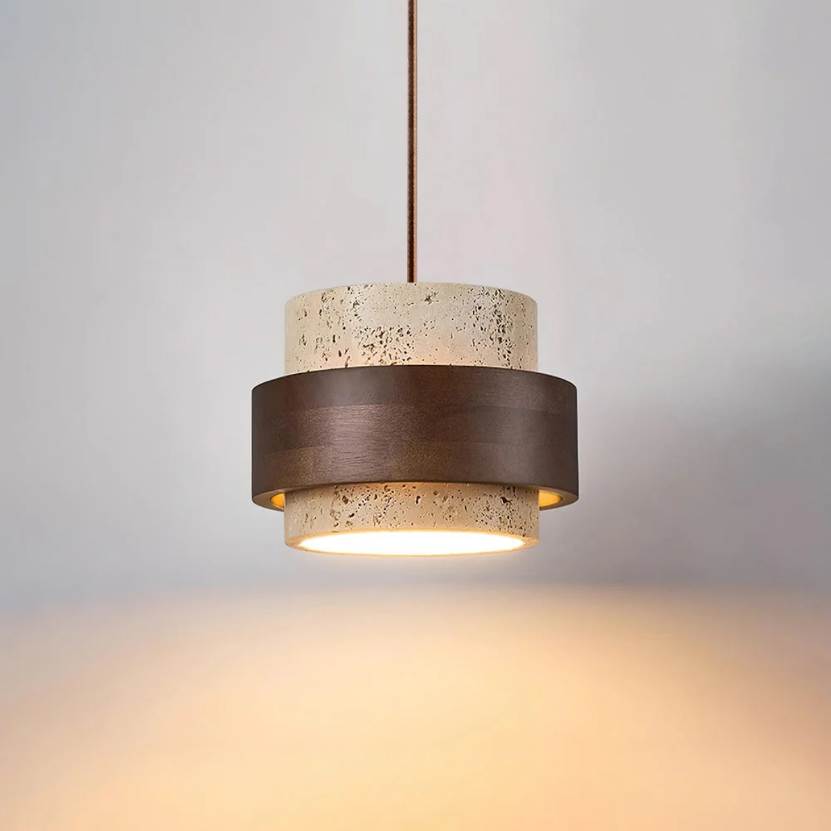 TerraHalo pendant lit, hanging from ceiling showing travertine and walnut wood two-tier shade