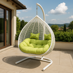 Hanging chair with green cushions on a patio with a scenic background