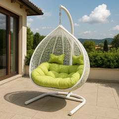 Hanging chair with green cushions on a patio with a scenic background