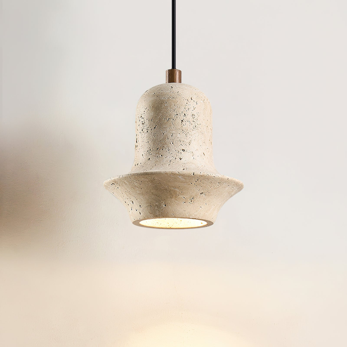 Bellora Sculpted Travertine Pendant Light - front view, lit, warm halo underglow