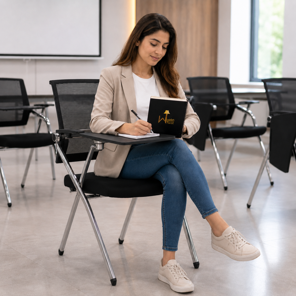 Woman writing on the tablet arm of a Wooden Twist stackable training chair with chrome frame