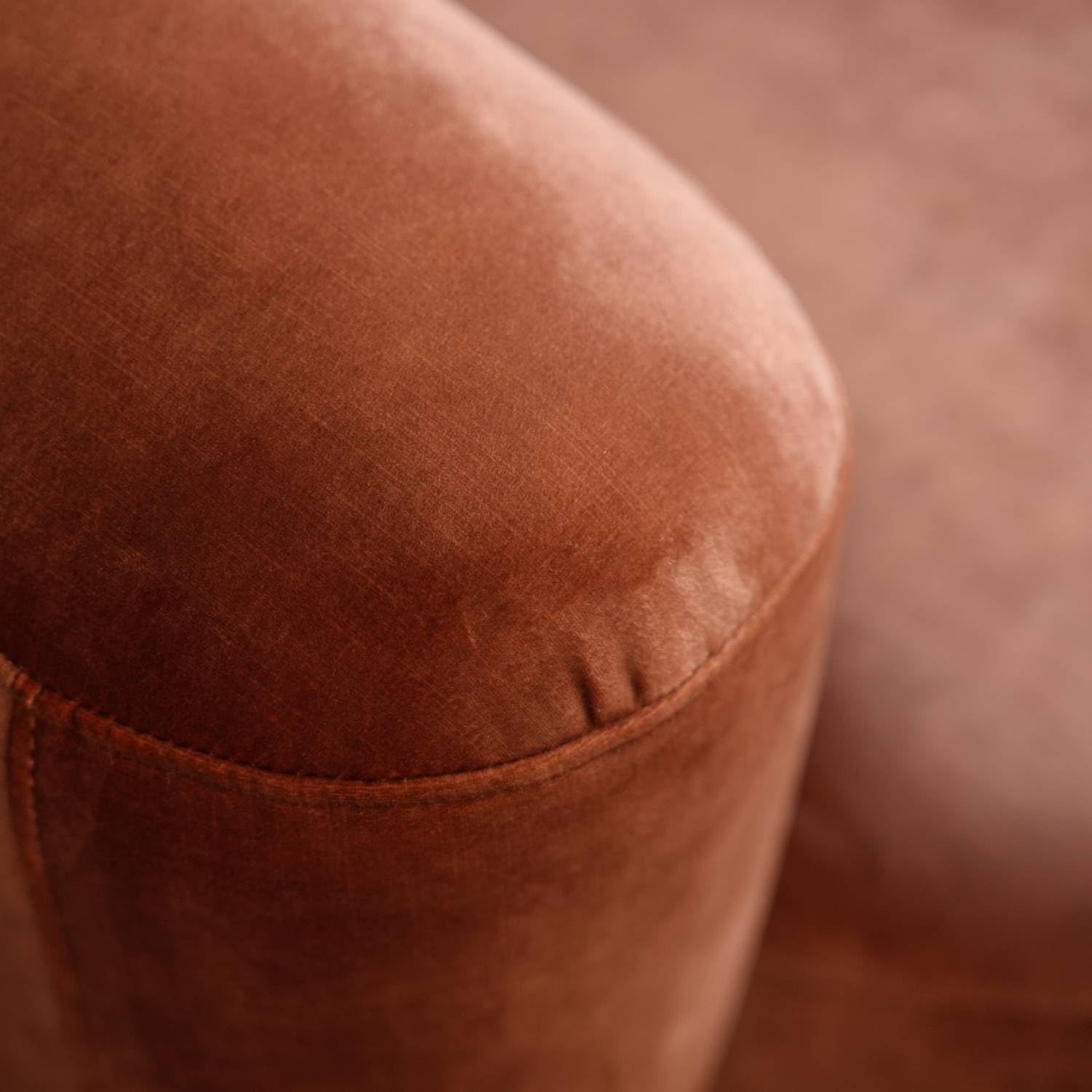 Close-up of a brown leather ottoman with a blurred background