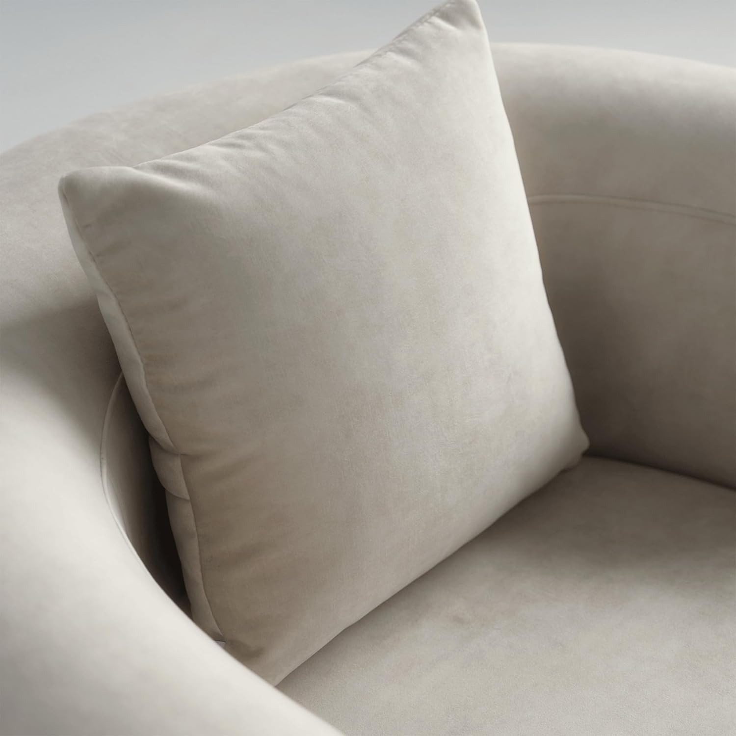 Beige pillow on a beige sofa against a white background