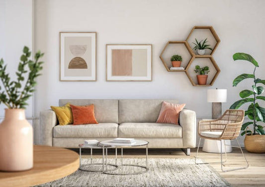 Modern minimalist living room with a beige sofa, neutral cushions, round coffee tables, framed wall art, hexagon shelves with plants, a wicker accent chair, and indoor greenery in soft natural tones.