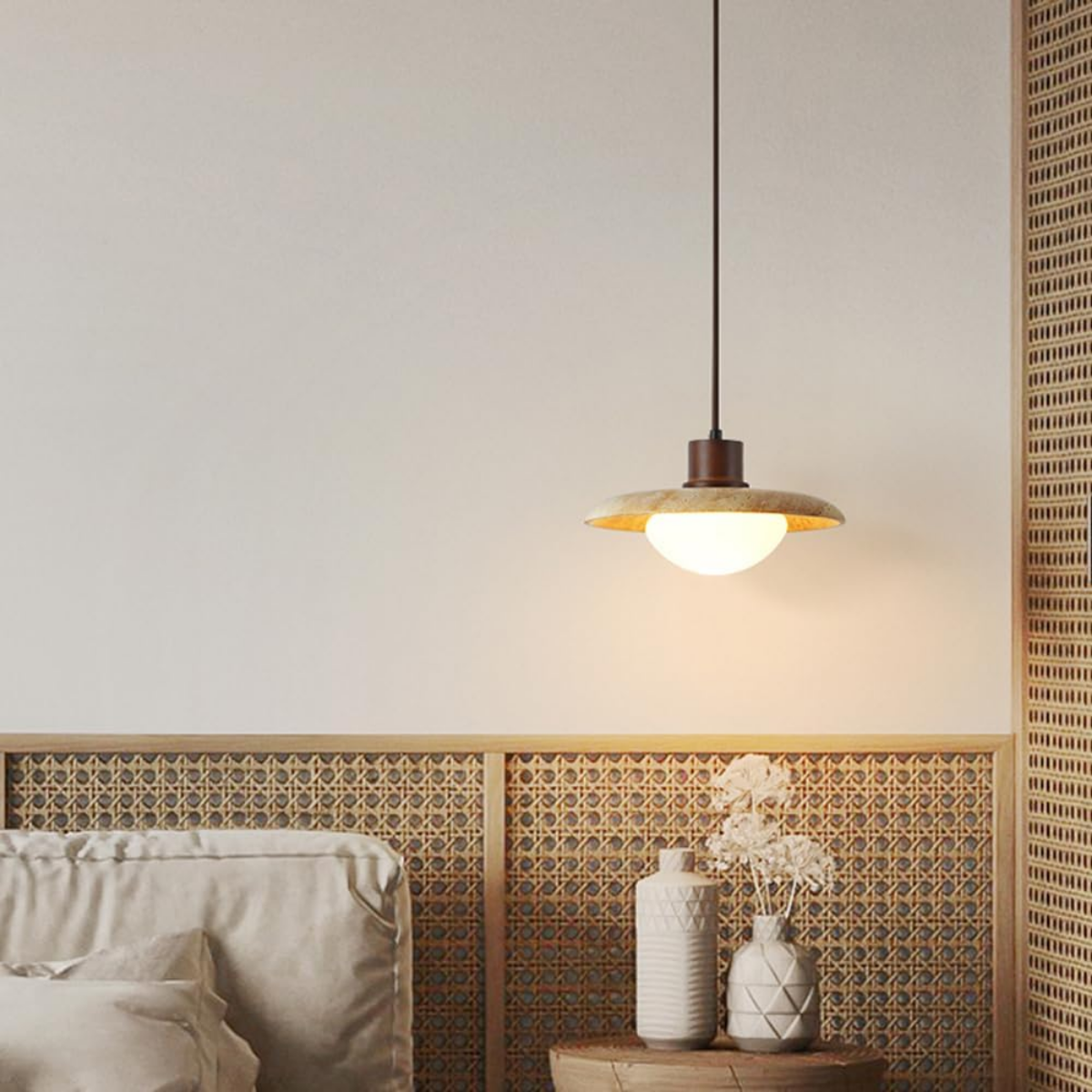 Aurelia Wabi-Sabi Travertine Pendant Light hanging above a bedside table with rattan headboard