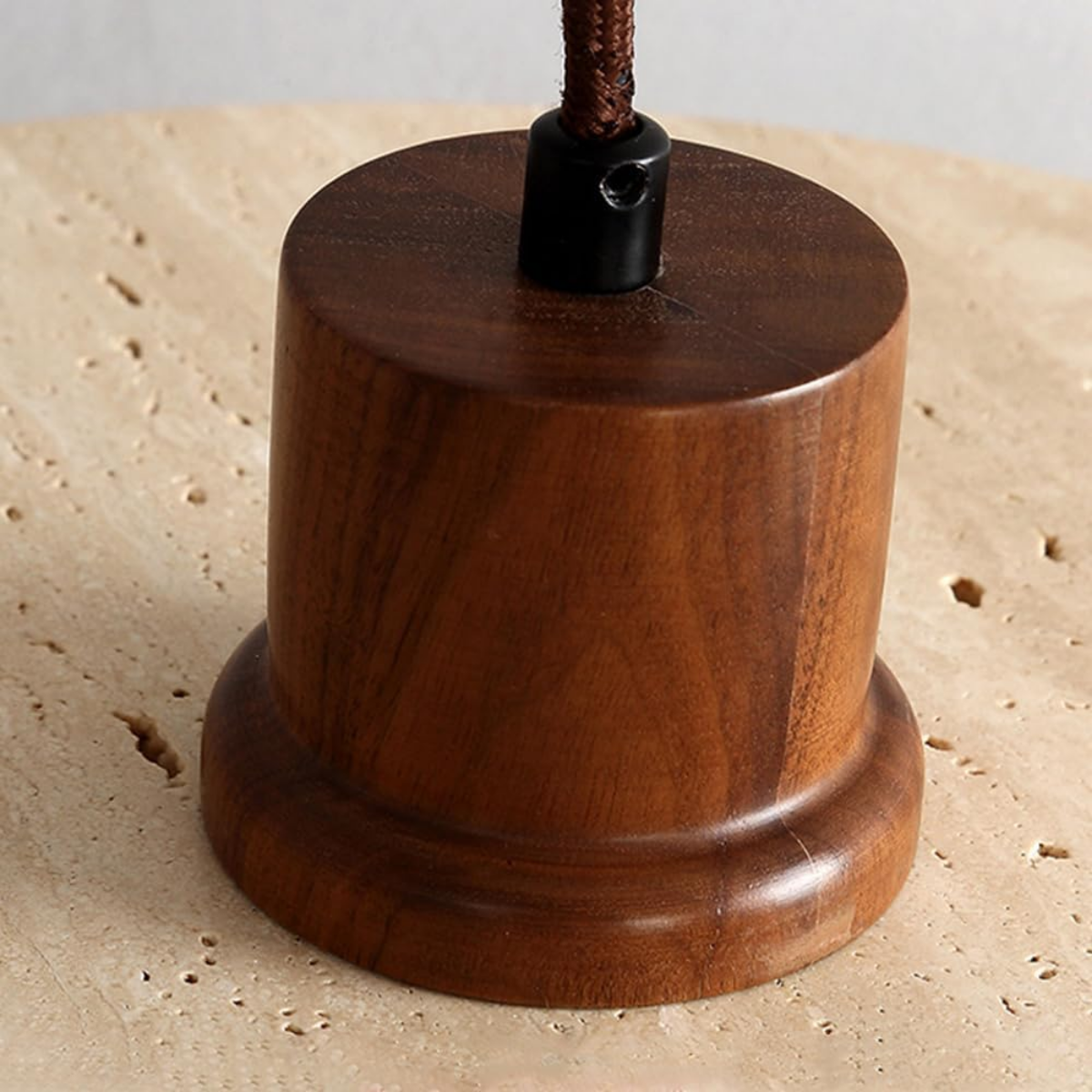 Close-up of the solid walnut wood cup fitting on Aurelia Travertine Pendant Light