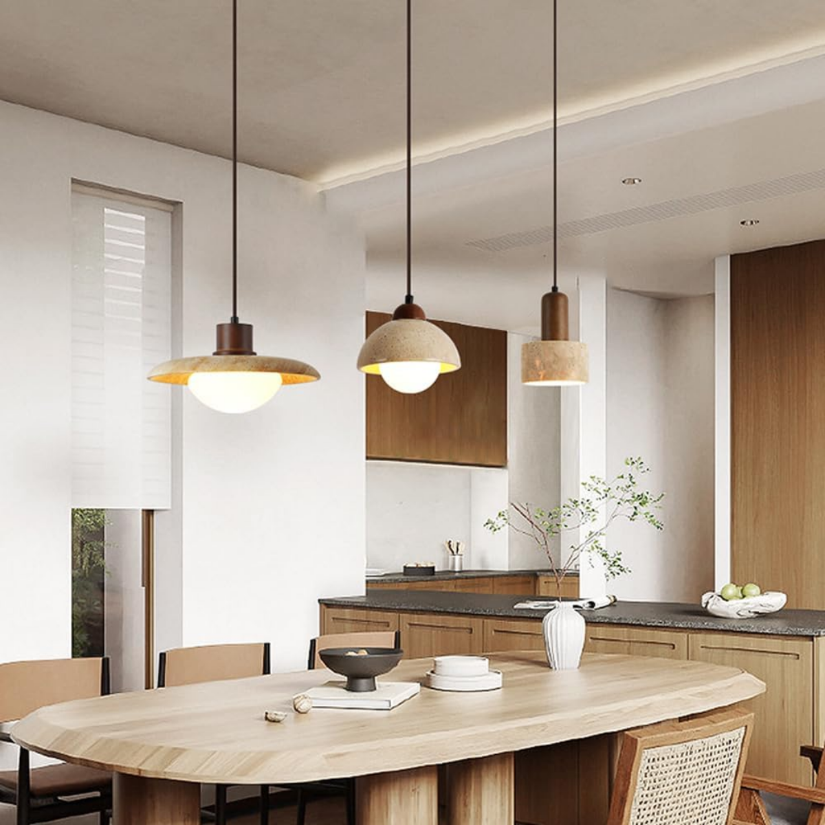 Three Aurelia Wabi-Sabi Travertine Pendant Lights hanging above a kitchen island dining table