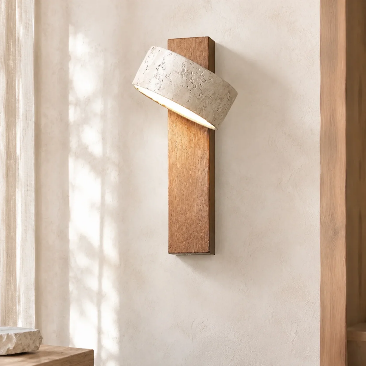 Aurevo Travertine Rotatable Wall Lamp mounted on a textured wall beside a wood door frame, natural light setting