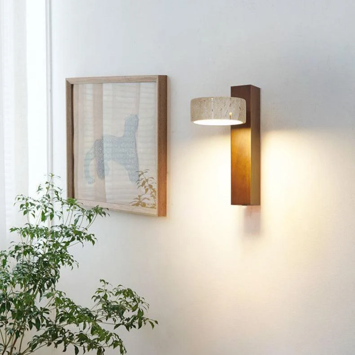 Aurevo Travertine Rotatable Wall Lamp beside framed wall art and a potted plant in a living room