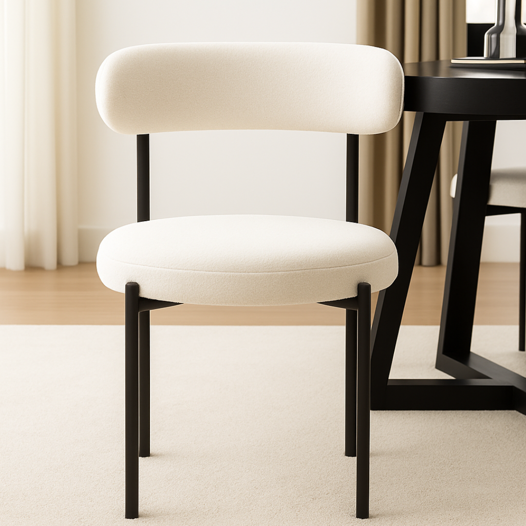 White chair with black legs in a room with a table and curtains.