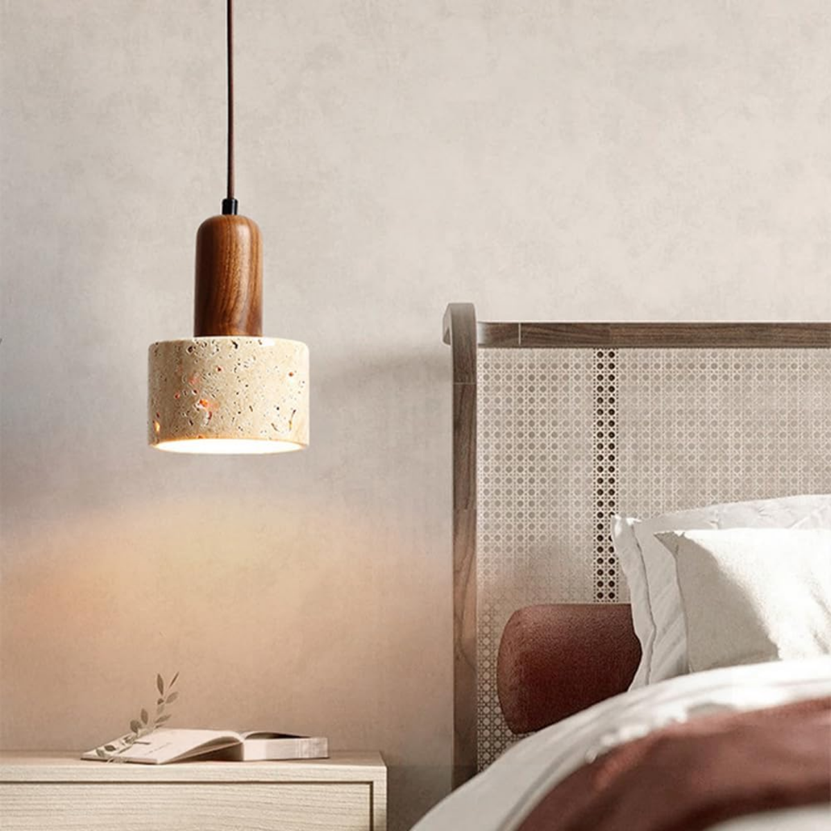Aurelia Travertine Cylinder Pendant Light hanging above a bedside table near abstract wall art