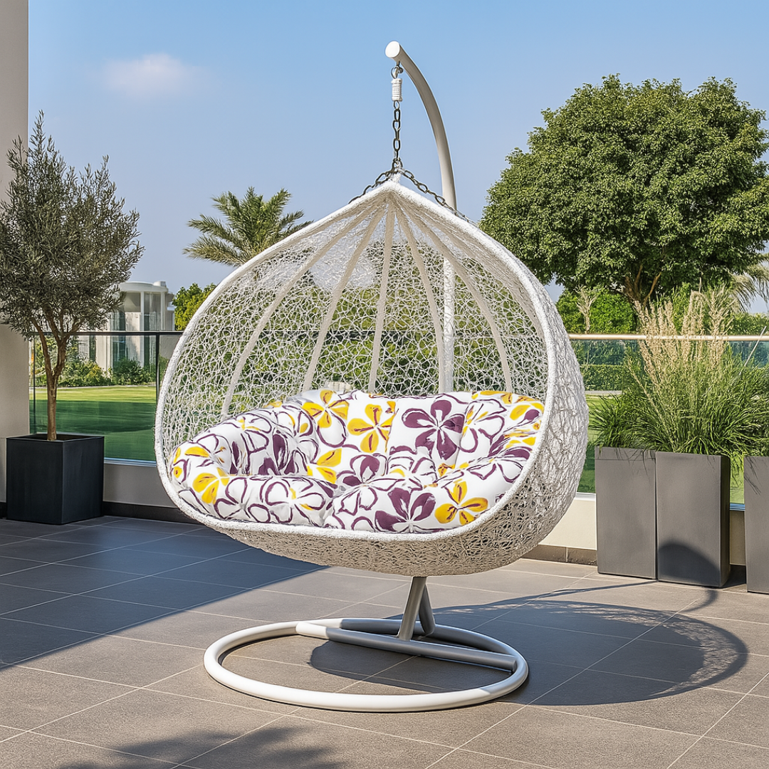 White hanging egg chair with a floral cushion on a patio