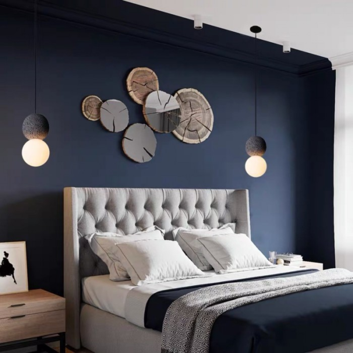 lifestyle two pendants flanking a wall art display above a navy bedroom headboard