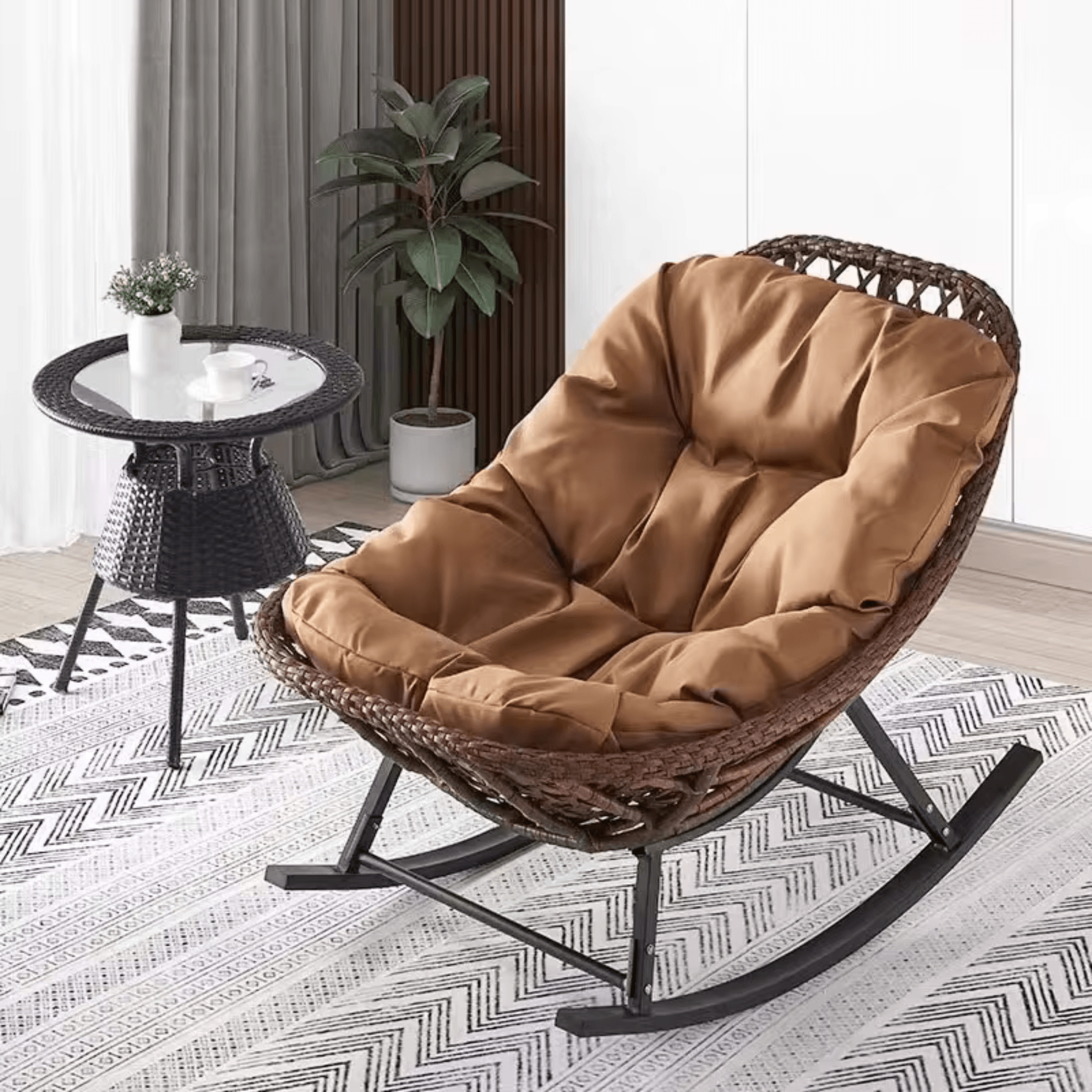 Reclining rattan outdoor rocking chair with cushion in a modern patio setting