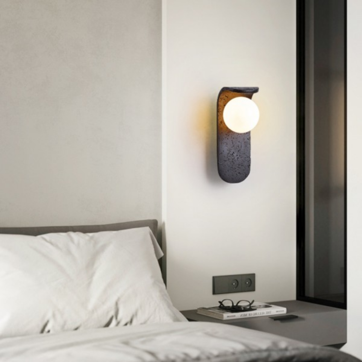 Skatera Travertine Wall Lamp installed beside a bedroom window and nightstand