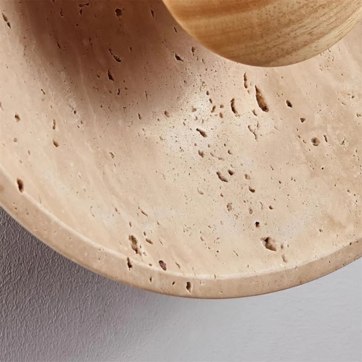 Close-up texture detail of natural yellow travertine stone surface on Solara Round Wall Light