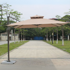 Large beige patio umbrella on a wooden deck with trees and buildings in the background