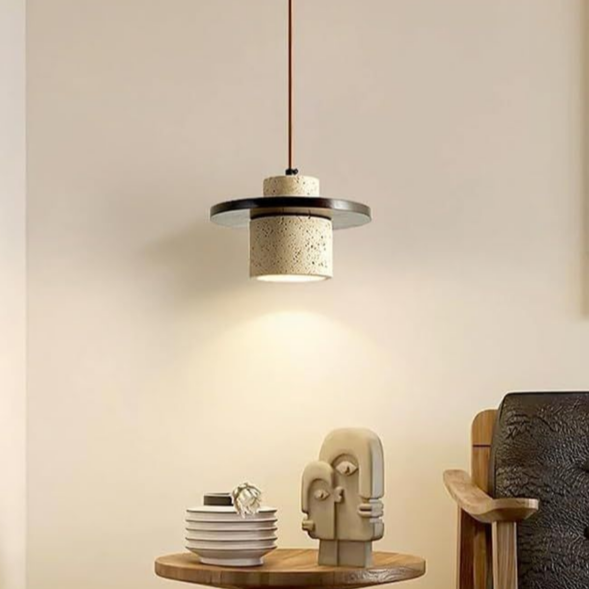 TerraLoop pendant lit above a side table with sculptural bookend decor