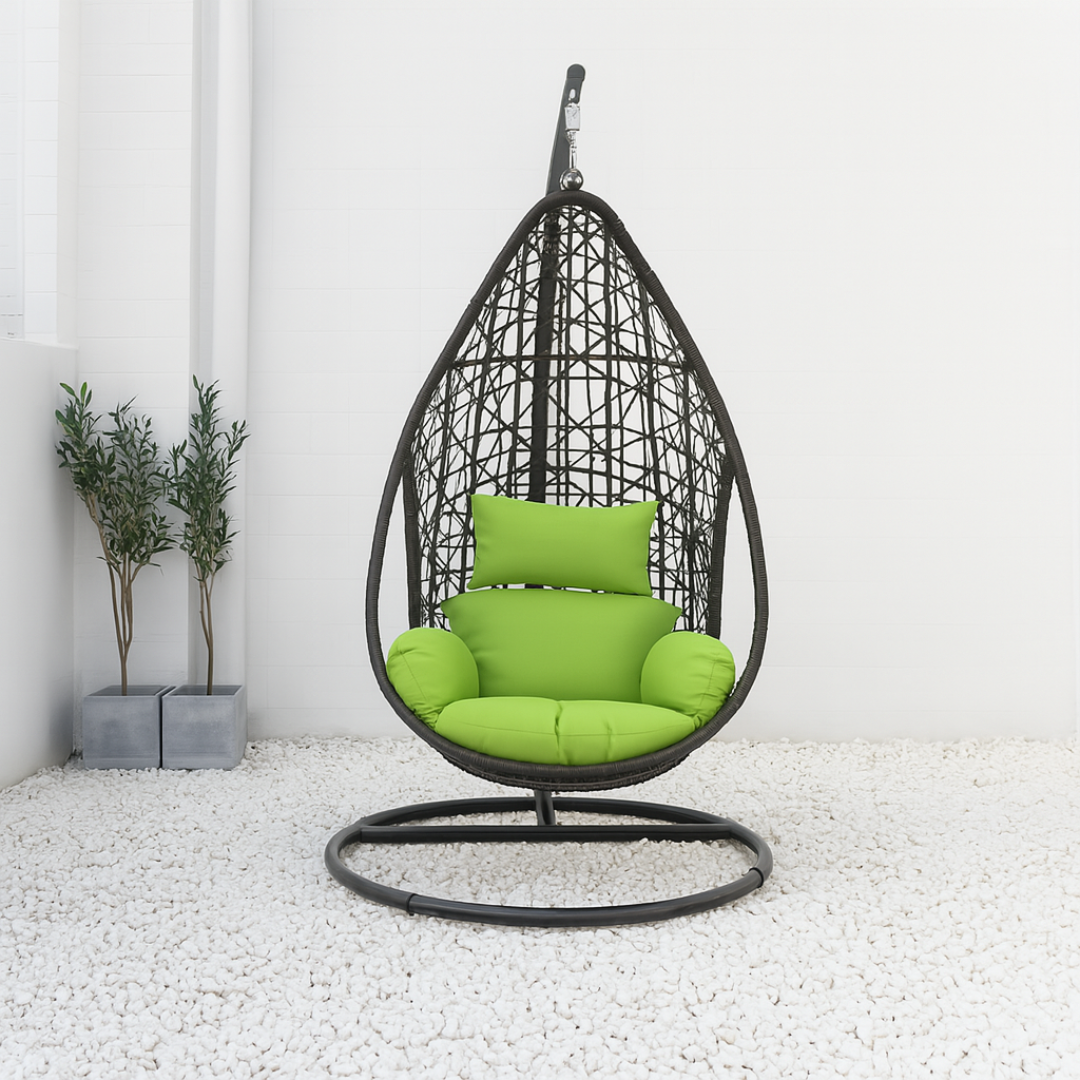 Hanging chair with green cushions on a white floor and light gray walls