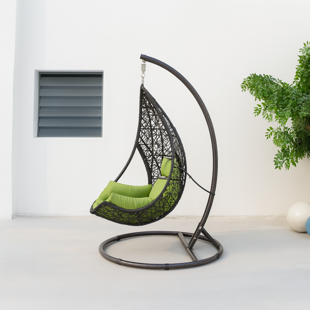 Hanging egg chair with green cushion on a white floor and light gray wall background