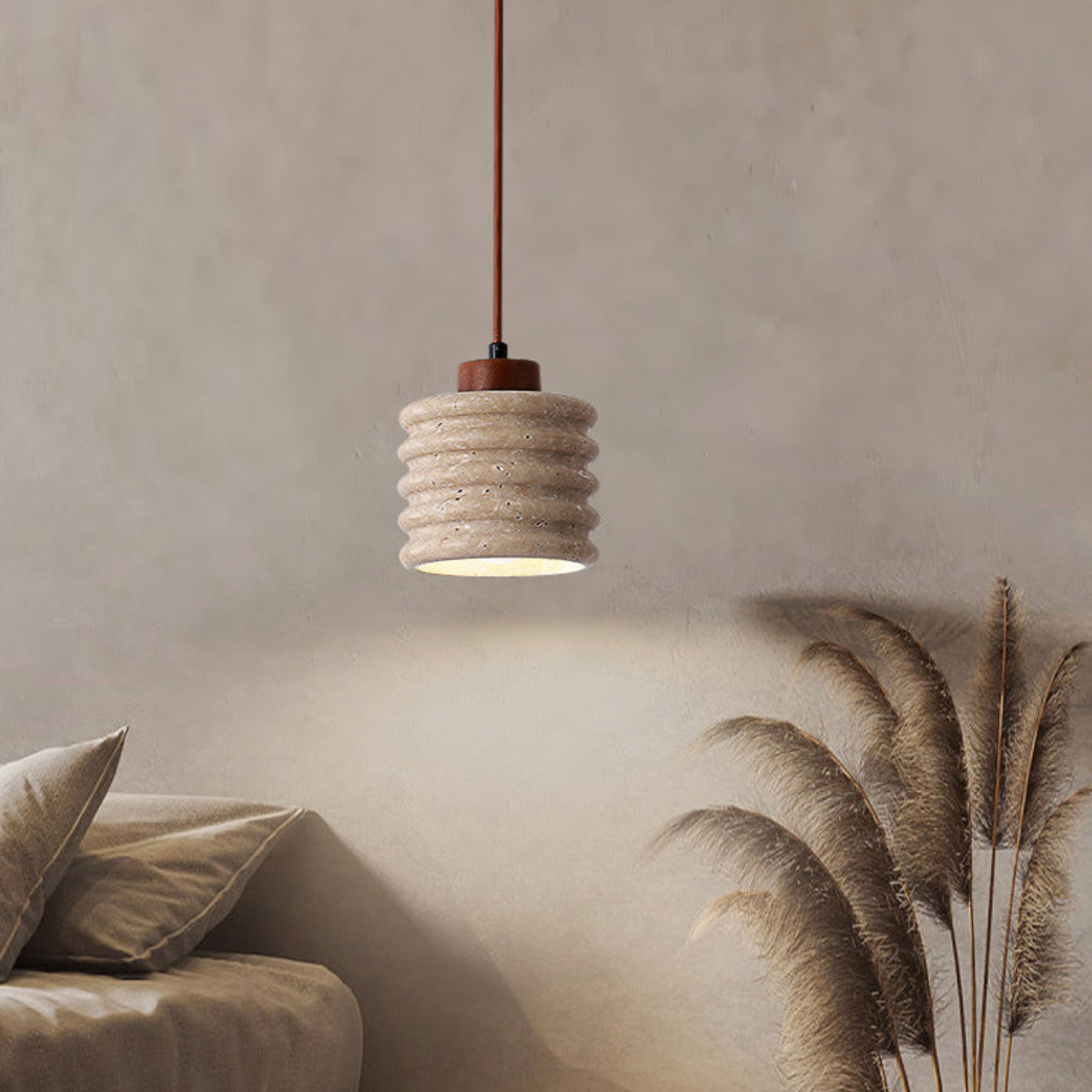 Ribelle Travertine Pendant Light - lifestyle above a sofa with pampas grass decor