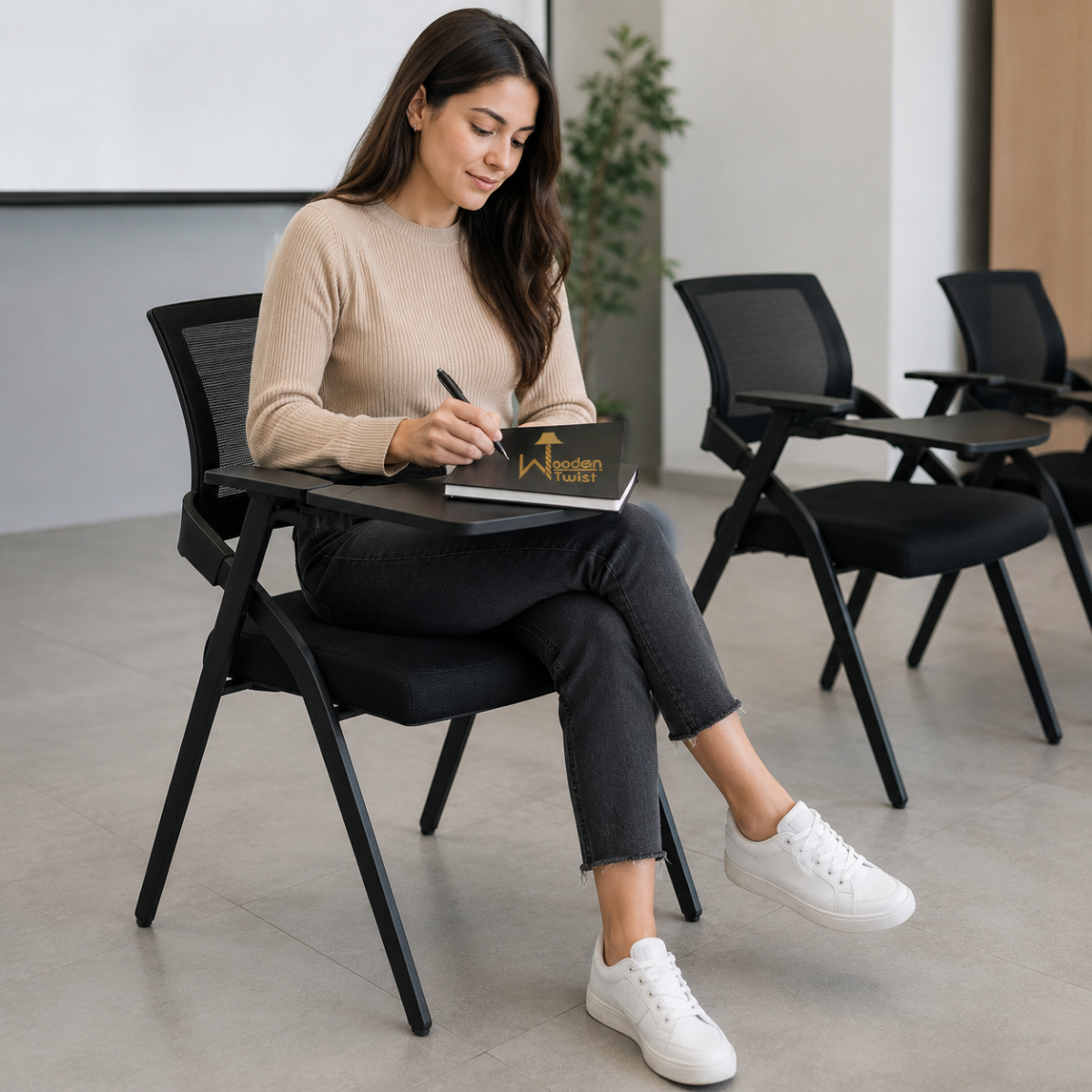 Woman writing on the tablet arm of a Wooden Twist stackable training chair