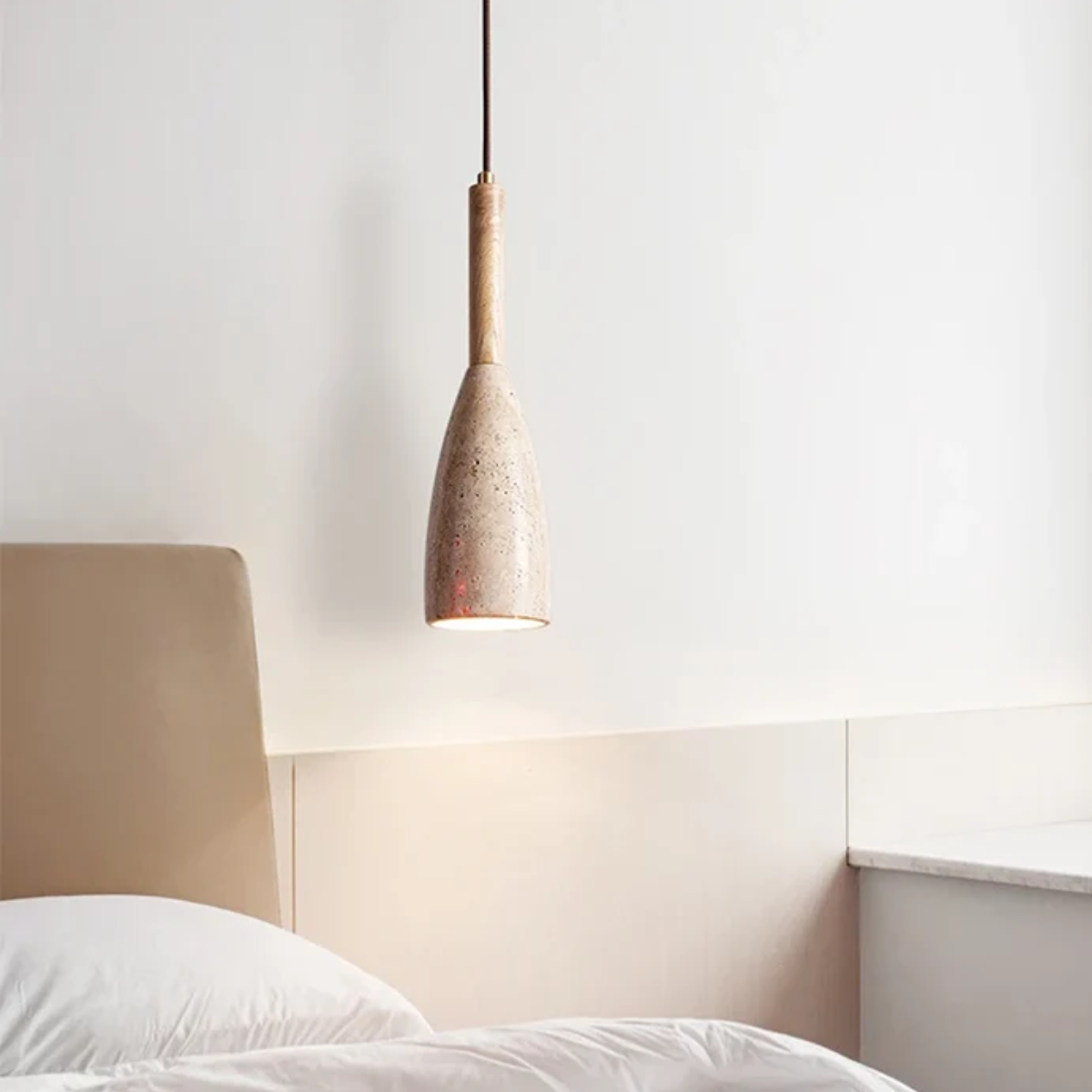 Vellora Travertine Drop Pendant Light Natural - lifestyle above a nightstand with wood headboard