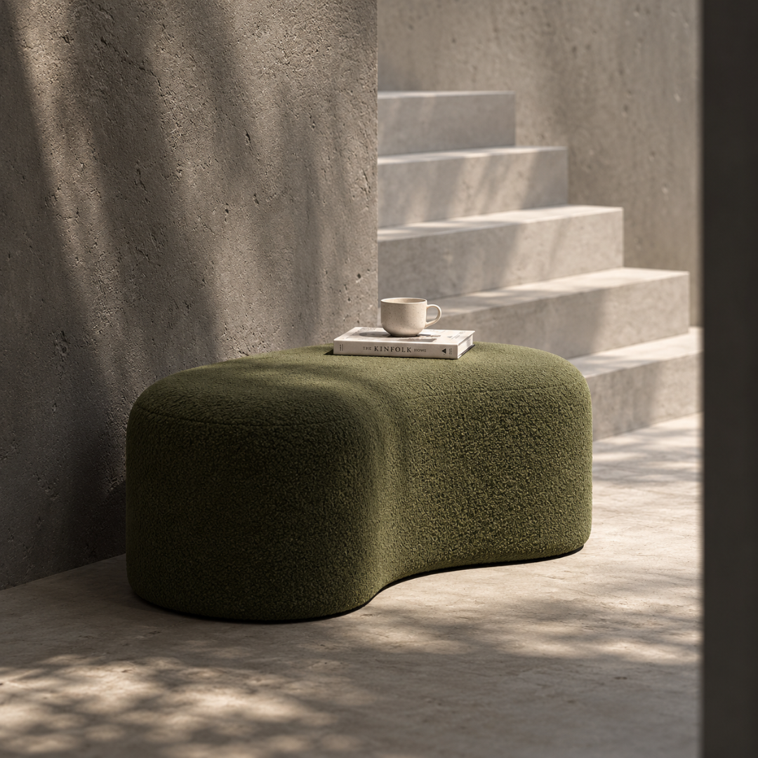 Wooden Twist Fern olive green boucle bean-shaped bench ottoman in a minimalist concrete room