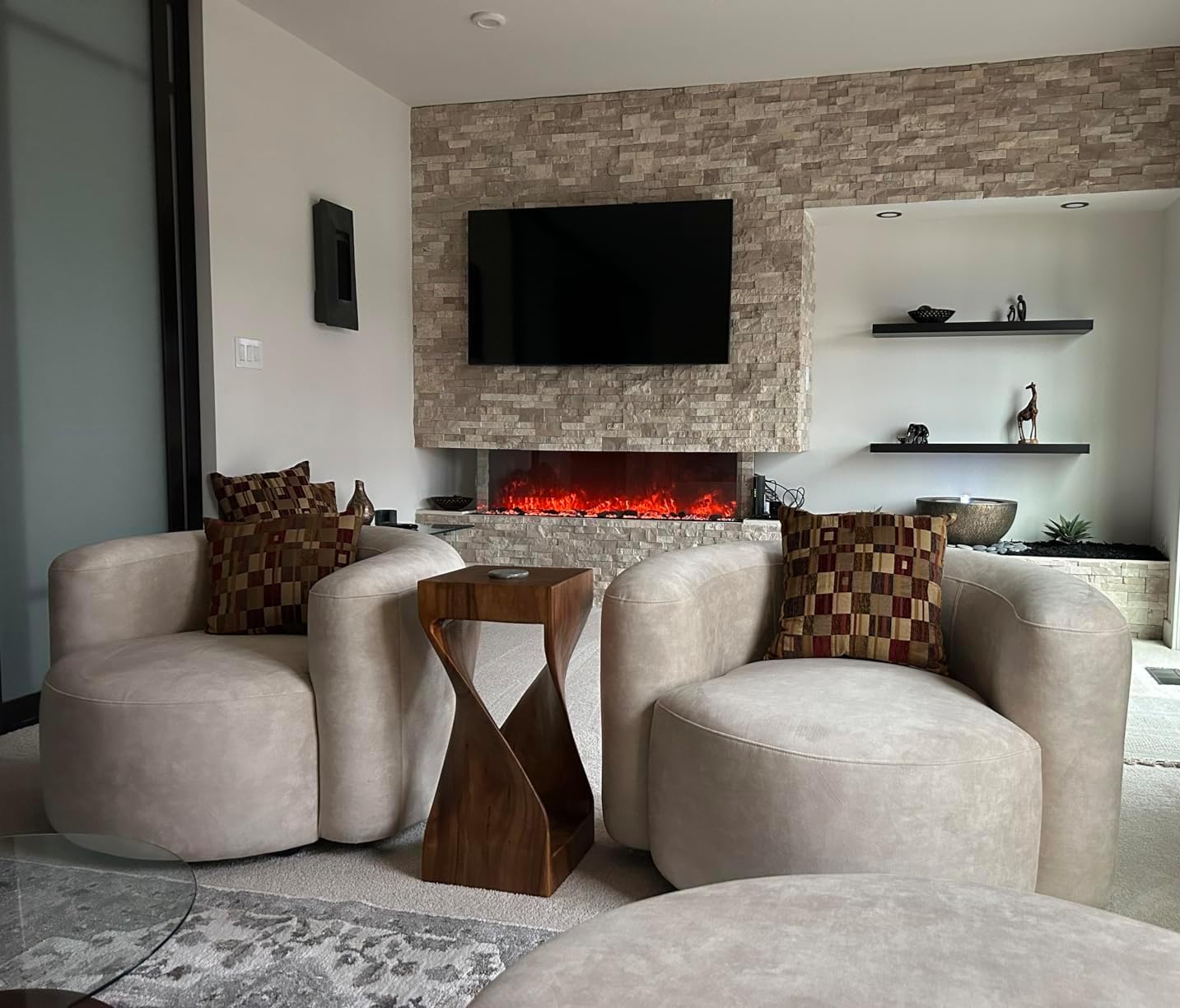 Modern living room with a fireplace, television, and comfortable seating.