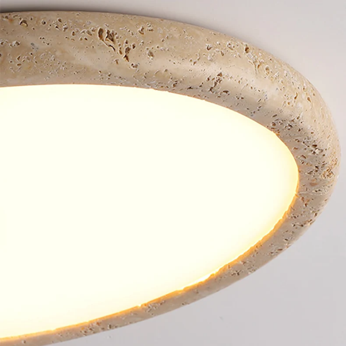 Close-up of Zenora Travertine LED Ceiling Light rim showing natural travertine texture and light glow